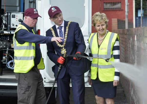 Probations John Finnegan, shows Belfast Lord Mayor Brian Kingston and Probation chief executive Cheryl Lamont, how to operate the specialised graffiti-removing power washer