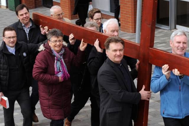 Lisburn clergy carrying the cross for the annual walk of witness through the city last Easter