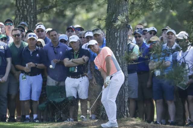 Rory McIlroy of Northern Ireland, hits from the rough on the first hole during the final round of the Masters