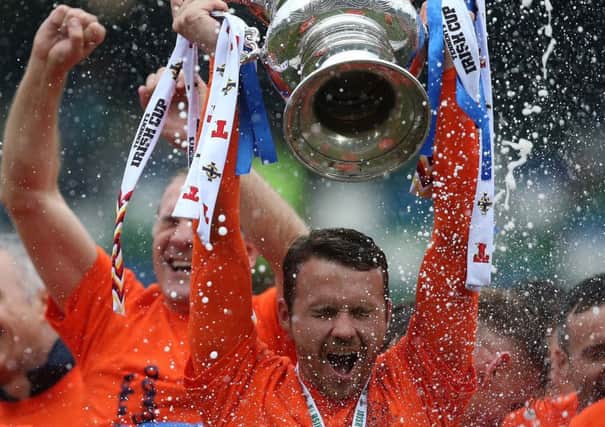 Glenavon's Mark Patton 
with the Tennents' Irish Cup following last year's final