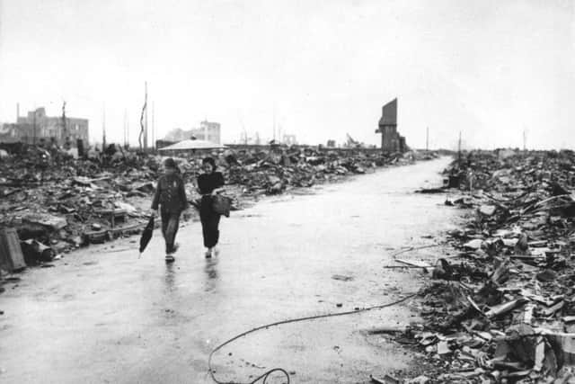 In September 1945 two people walk on a cleared path through the destruction resulting from the Aug 6 detonation of the first atomic bomb in Hiroshima, western Japan. (AP Photo/U.S. Air Force, File)