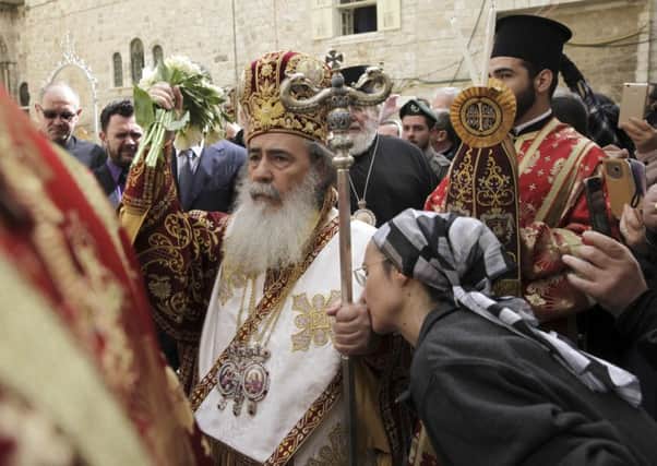 Christian rituals: A pilgrim kisses the hand of Greek Orthodox Patriarch of Jerusalem Teophilos III during the Washing of the Feet ceremony outside the Church of the Holy Sepulchre, traditionally believed by many to be the site of the crucifixion and burial of Jesus Christ, in Jerusalem's Old City, on Maunday Thursday, 2017. (AP Photo/Mahmoud Illean)