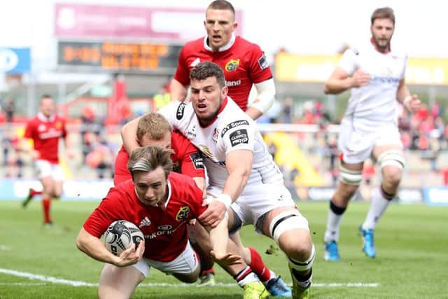 Munster's Angus Lloyd scores a try despite Sean Reidy of Ulster