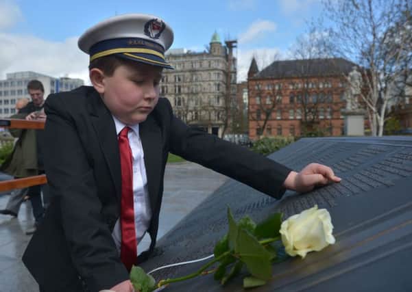 Liam McDonald from Belfast leaves a rose in memory of the victims of the Titanic during the 105th memorial service held at City Hall on Saturday. Photo by Aaron McCracken/Harrisons