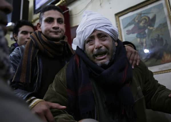 A man is comforted by others as he mourns over Egyptian Coptic Christians who were captured in Libya and killed by militants affiliated with the Islamic State group, in the village of el-Aour, near Minya, 220 kilometers (135 miles) south of Cairo, Egypt in 2015. Christians are increasingly vulnerable in the Middle East. (AP Photo/Hassan Ammar)