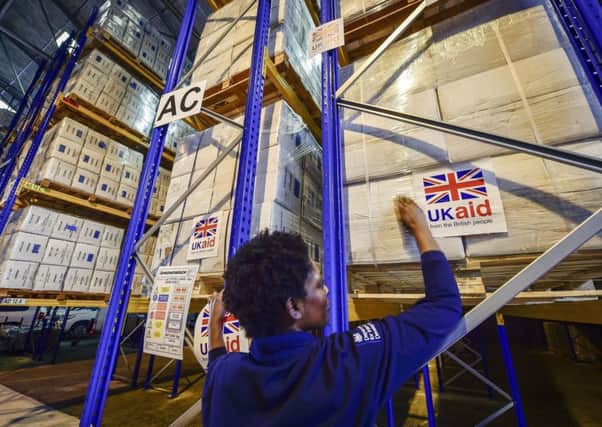 A logistics officer placing UK aid stickers onto cargo pallets containing British aid items destined for areas suffering humanitarian crisis at DFID's UK Disaster Response Operations Centre at Cotswold Airport, Kemble. Photo: Ben Birchall/PA Wire
