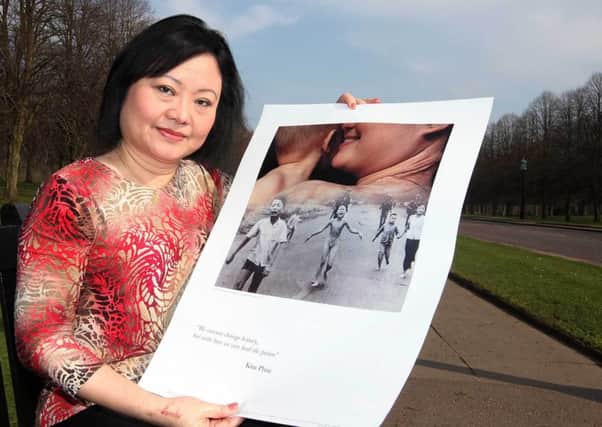 Vietnam war napalm attack victim Kim Phuc Phan Thi in the Stormont estate in 2012, holding a copy of the Pulitzer Prize-winning photograph taken during the Vietnam War in June 1972 by AP photographer Nick Ut.  The picture shows her at about nine years of age running naked on a road after being severely burned on the back. Photo:Jonathan Porter/Presseye