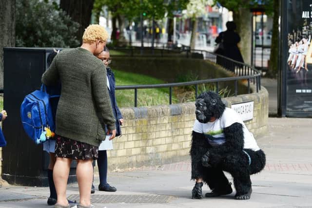 A woman looks at Metropolitan Police officer Tom Harrison, who goes by the name Mr Gorilla