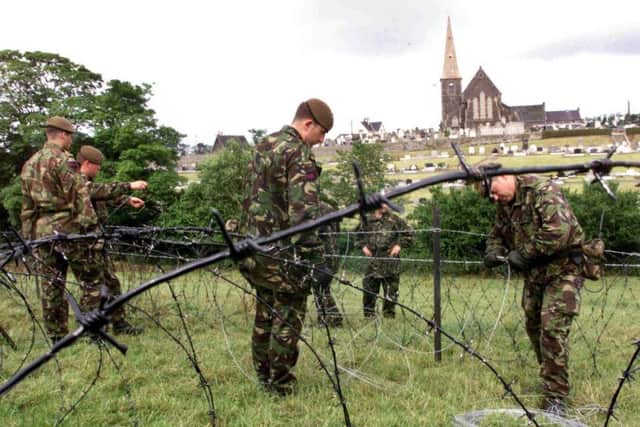 1999: British soldiers errect rows of razor wire in the fields surrounding Drumcree church in preparation for an Orange parade.