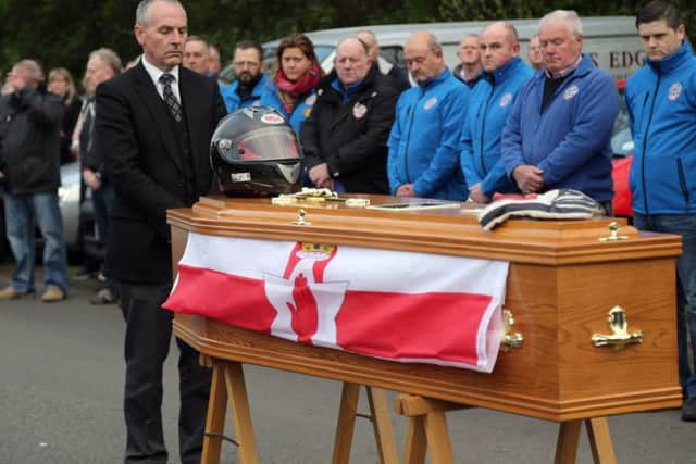 An Ulster flag is draped on the coffin of Dario Cecconi during a service at the start line on theTandragee 100 circuit in Co Armagh.