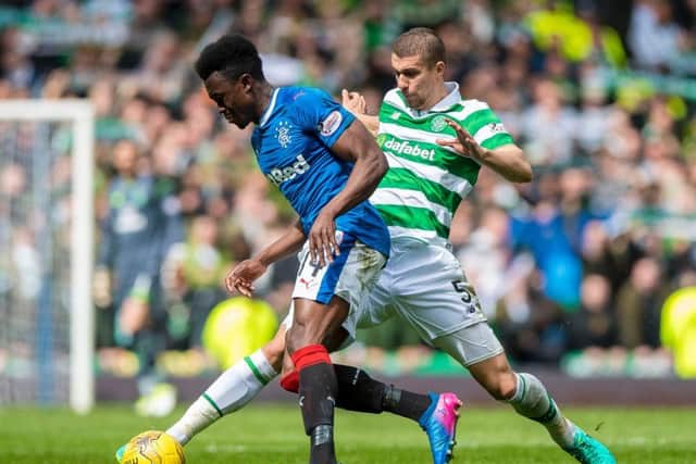 Celtic's Jozo Simunovic and Rangers' Joe Dodoo compete for the ball d