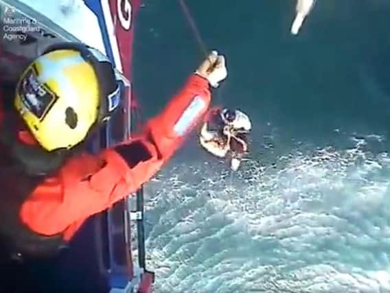 Screen grabbed image taken from video issued by the Maritime & Coastguard Agency of the moment surfer Matthew Bryce, who survived more than 30 hours stranded at sea on his board, was rescued