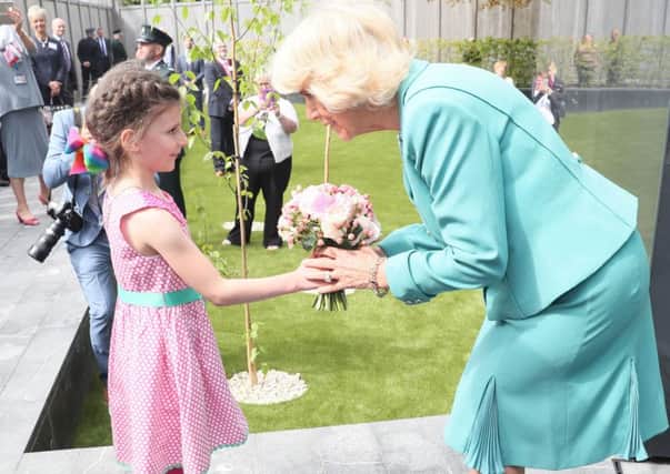 The Duchess of Cornwall is presented with a posy of flowers by seven year old Victoria Grieves during the opening of the memorial garden at the Police Service of Northern Ireland HQ  in Belfast as part of her visit to Northern Ireland