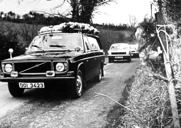 The hearse carrying Kingsmills victim Robert Freeburn drives past the scene of the massacre after his funeral in January 1976
