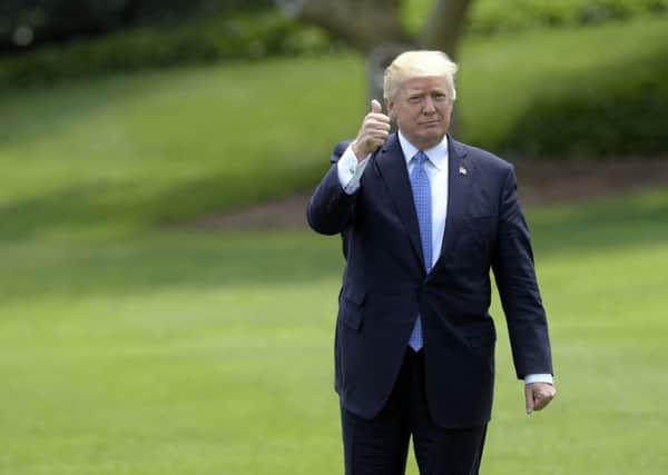 President Donald Trump gives a thumbs-up as he walks across the South Lawn of the White House in Washington on Friday (AP Photo/Susan Walsh)
