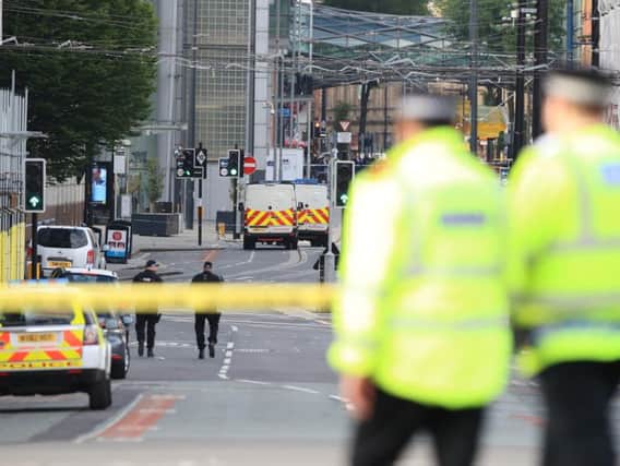 Police close to the Manchester Arena the morning after a suspected terrorist attack at the end of a concert by US star Ariana Grande left 22 dead.