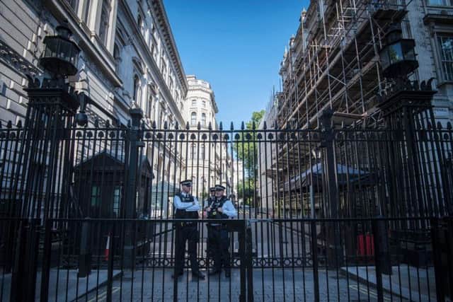 Police outside Downing Street in London, after Scotland Yard announced armed troops will be deployed to guard "key locations".