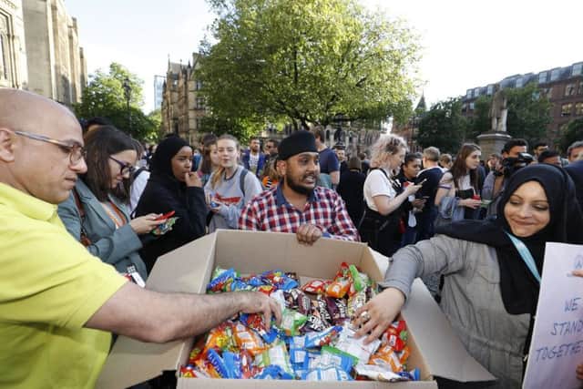 A man gives out food during the Manchester vigil