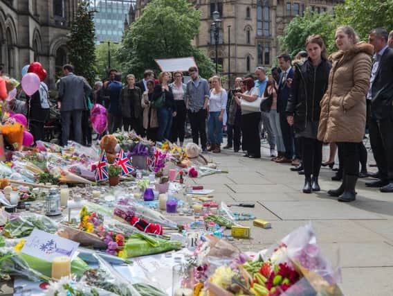 People lay flowers outside the Town Hall in Albert Square, Manchester after a suicide bomber killed 22 people leaving a pop concert at the Manchester Arena on Monday night.