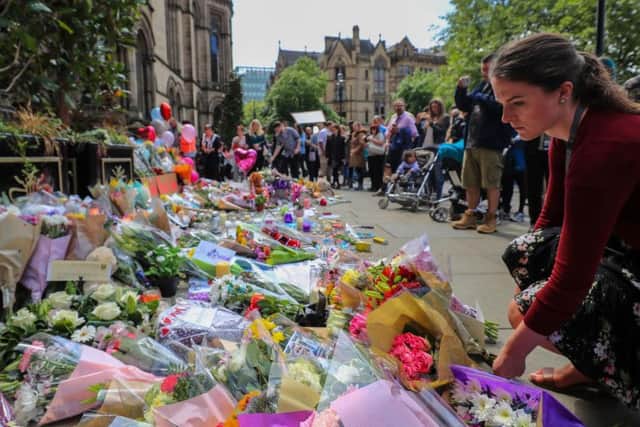 People lay flowers outside the Town Hall in Albert Square, Manchester after a suicide bomber killed 22 people leaving a pop concert at the Manchester Arena on Monday night.