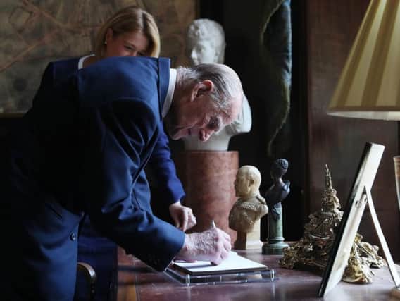 The Duke of Edinburgh signs the visitor book following the Duke of Edinburgh's Award gold award presentations at Hillsborough Castle in Co Down.