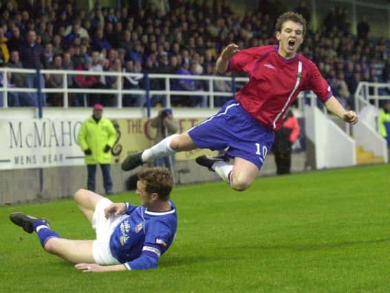 Linfield's Ryan McCann feels the full force of this tackle from Glenavon defender Pete Batey at Mourneview Park
