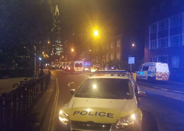Police vehicles in a street near London Bridge with the Shard tower in the background during the ongoing terrorist incidents at London Bridge and Borough Market