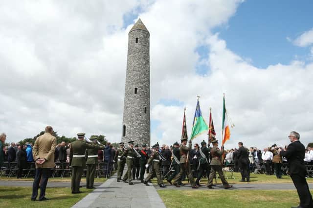 Troops march past the Irish-style tower at the Island of Ireland Peace Park