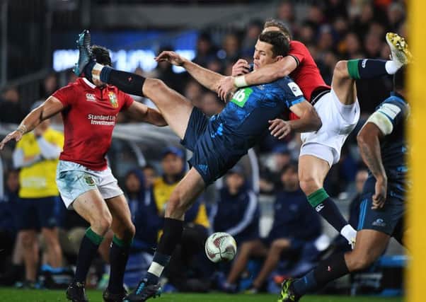 Blues' Matt Duffie is tackled by Liam Williams of the Lions