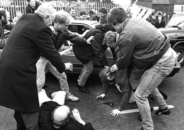 One of the two army corporals Derek Woods emerges from his car and drops his  his gun while being attacked at an IRA funeral on the Andersonstown road in Belfast in 1988