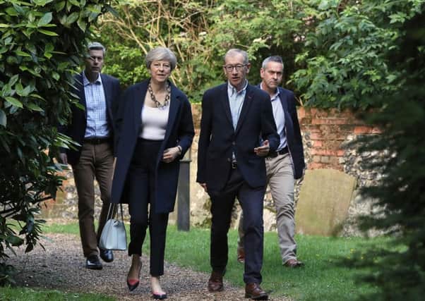 Prime Minister Theresa May and her husband Philip (centre) arrive to attend a service at St Andrew's Church in Sonning, Berkshire