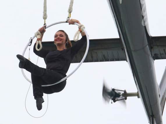 Erendira Wallenda performs a series of acrobatic maneuvers, including hanging by her teeth, while suspended from a helicopter above Niagara Falls