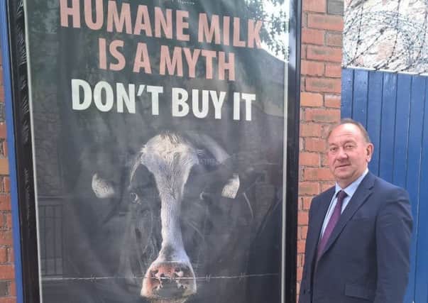William Irwin MLA is pictured with one of the contentious anti-dairy billboards in Armagh City and also with one of his dairy cows which he says"clearly shows just how much care dairy cows receive".