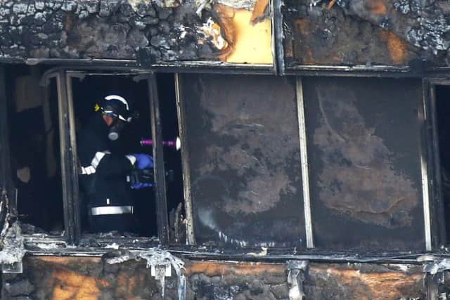Fire service personnel survey the damage to Grenfell Tower in west London