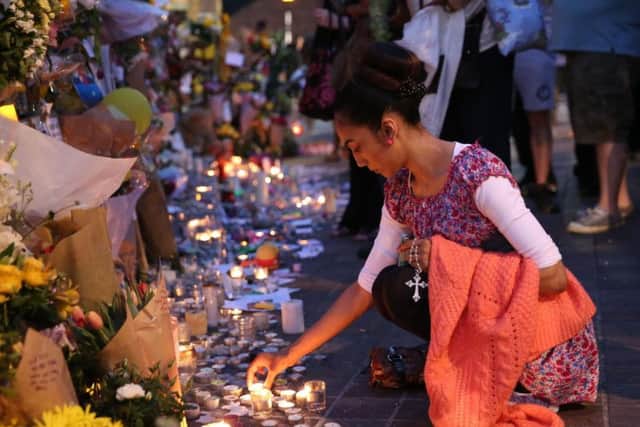 People look at tributes an dlight candles at Notting Hill Methodist Church near Grenfell Tower in west London after a fire engulfed the 24-storey