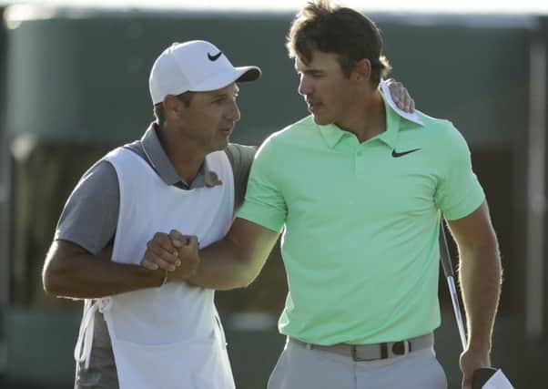 Brooks Koepka is congratulated by caddie Ricky Elliot from Northern Ireland