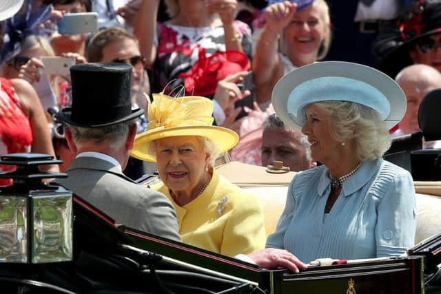The Queen, seated beside the Duchess of Cornwall, during the traditional horse-drawn carriage procession at Ascot