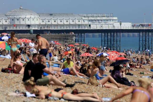 People enjoy the hot weather on the beach in Brighton, East Sussex. The temperature has hit 33.9C (93F) at Heathrow in west London, making it the hottest June day since 1976, the Met Office has said. Photo: Gareth Fuller/PA Wire