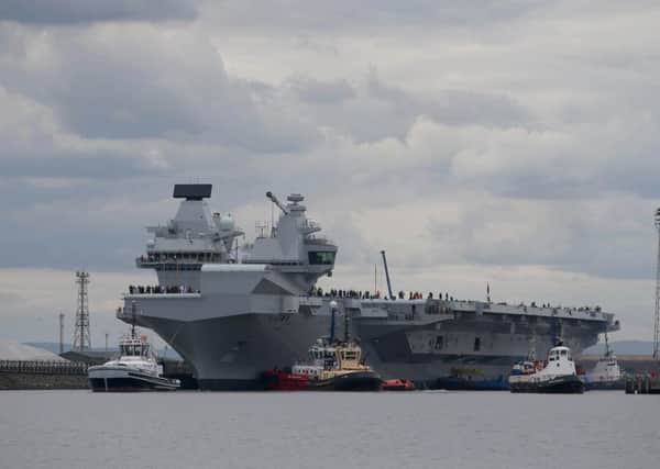 HMS Queen Elizabeth, one of two new aircraft carriers for the Royal Navy, begins to leave the Rosyth dockyard near Edinburgh to begin her sea-worthiness trials.