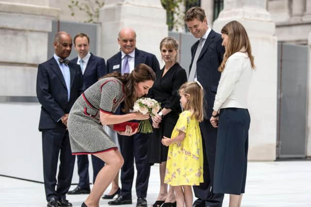 The Duchess of Cambridge receives flowers from six year old Lydia Hunt, the daughter of new director of the V&A museum Tristram Hunt