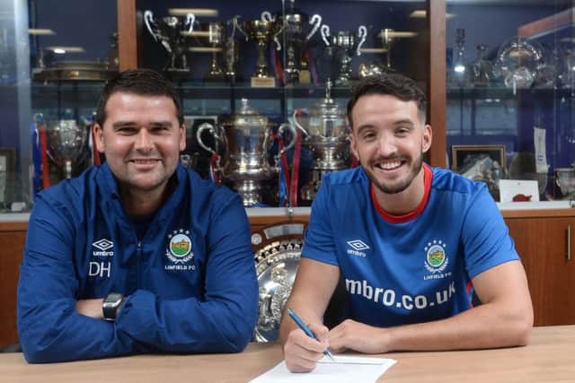 All smiles: Robinson puts pen to paper on the deal alongside Blues boss David Healy
