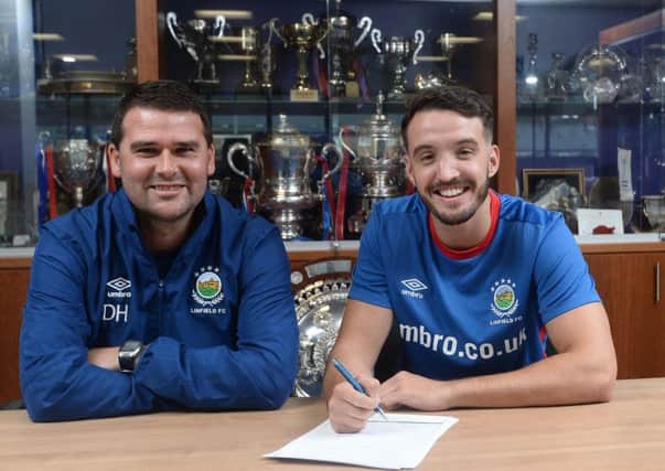All smiles: Robinson puts pen to paper on the deal alongside Blues boss David Healy