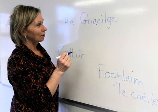 Linda Ervine  writing Irish on a white-board