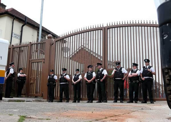 Police officers block the gates at Workman Avenue ahead of a previous Orange Order parade close to the Belfast peaceline