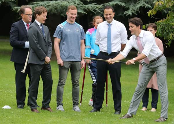 Canadian Prime Minister Justin Trudeau, watched by Dublin GAA footballer Ciaran Kilkenny, tries out a Hurling stick in the grounds of Farmleigh House in Dublin, after holding a press conference with Irish Taoiseach Leo Varadkar. Niall Carson/PA Wire