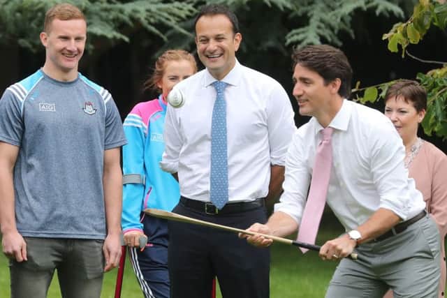 Canadian Prime Minister Justin Trudeau, watched by Dublin GAA footballer Ciaran Kilkenny, tries out a hurley in the grounds of Farmleigh House in Dublin, after holding a press conference with Irish Taoiseach Leo Varadkar. : Niall Carson/PA Wire