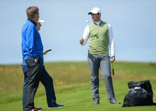 Rory McIlroy, right, along with Phil Kenyon, during putting practice ahead of the Dubai Duty Free Irish Open Golf Championship at Portstewart Golf Club