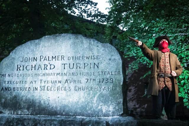 Simon Alnaimi, dressed as Dick Turpin, next to what was, until new evidence cast doubt on the claim, believed to be the grave of the infamous 18th century highwayman, in St Georges graveyard, York.