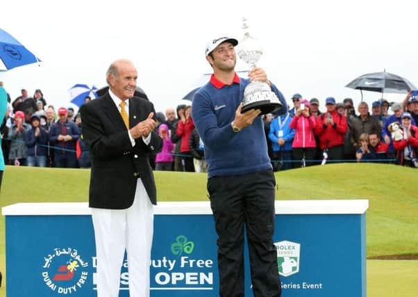 Jon Rahm is presented with the Dubai Duty Free Irish Open trophy by Colm McLoughlin - Executive Vice Chairman and CEO of Dubai Duty Free