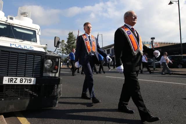 DUP councillor and erstwhile lord mayor of Belfast Brian Kingston (left, nearest the Land Rover) strides past the citys Ardoyne interface yesterday